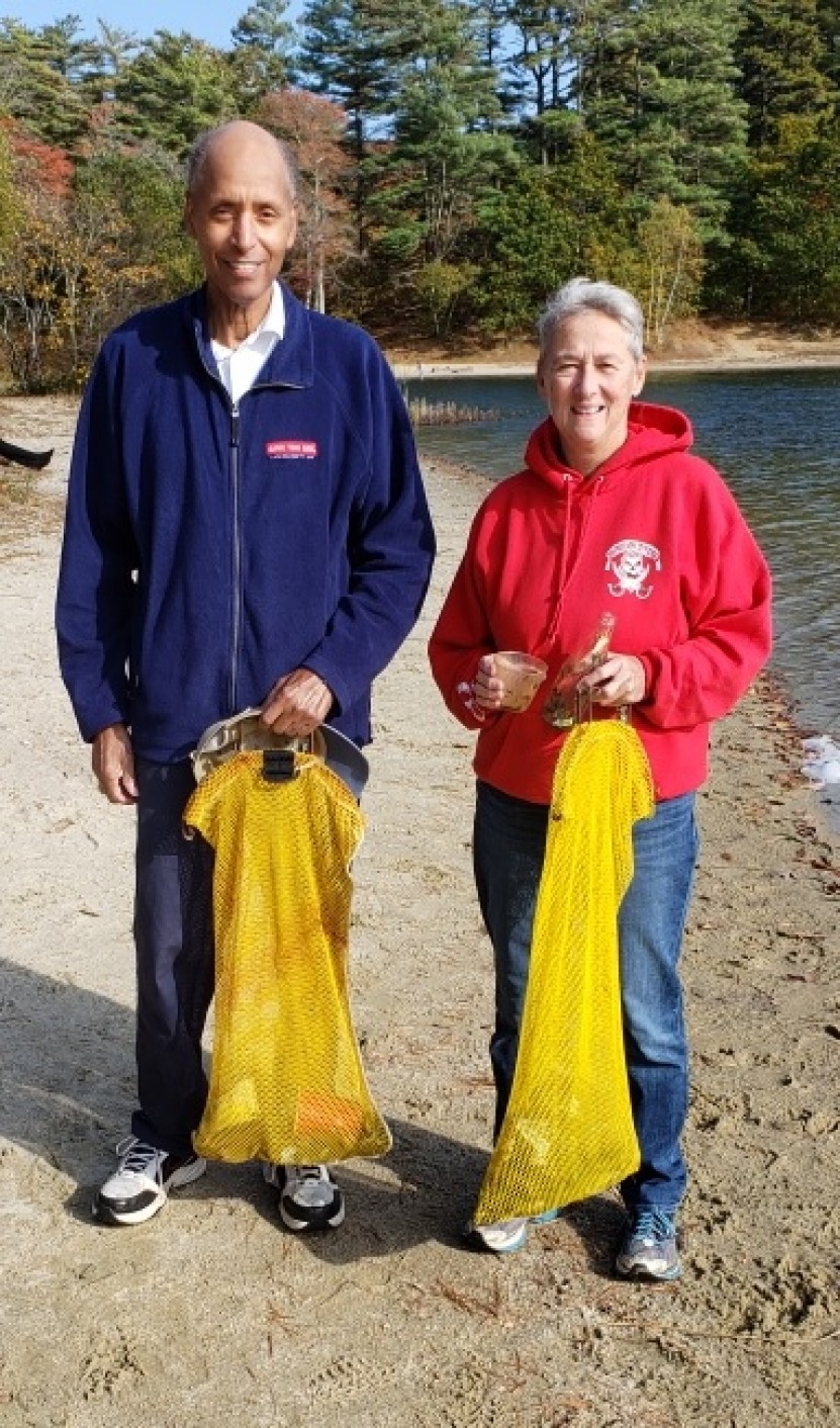 Two divers holding cattch bags with debris in them.