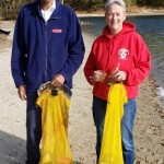 Two divers holding cattch bags with debris in them.